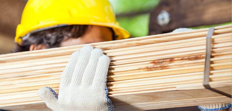 Builder carrying planks of wood