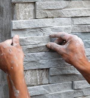 Stone mason mounting grey stones tiles