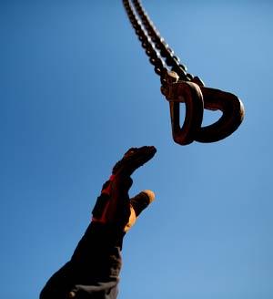 Hand reaching for a crane shackle