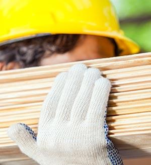 Builder carrying planks of wood